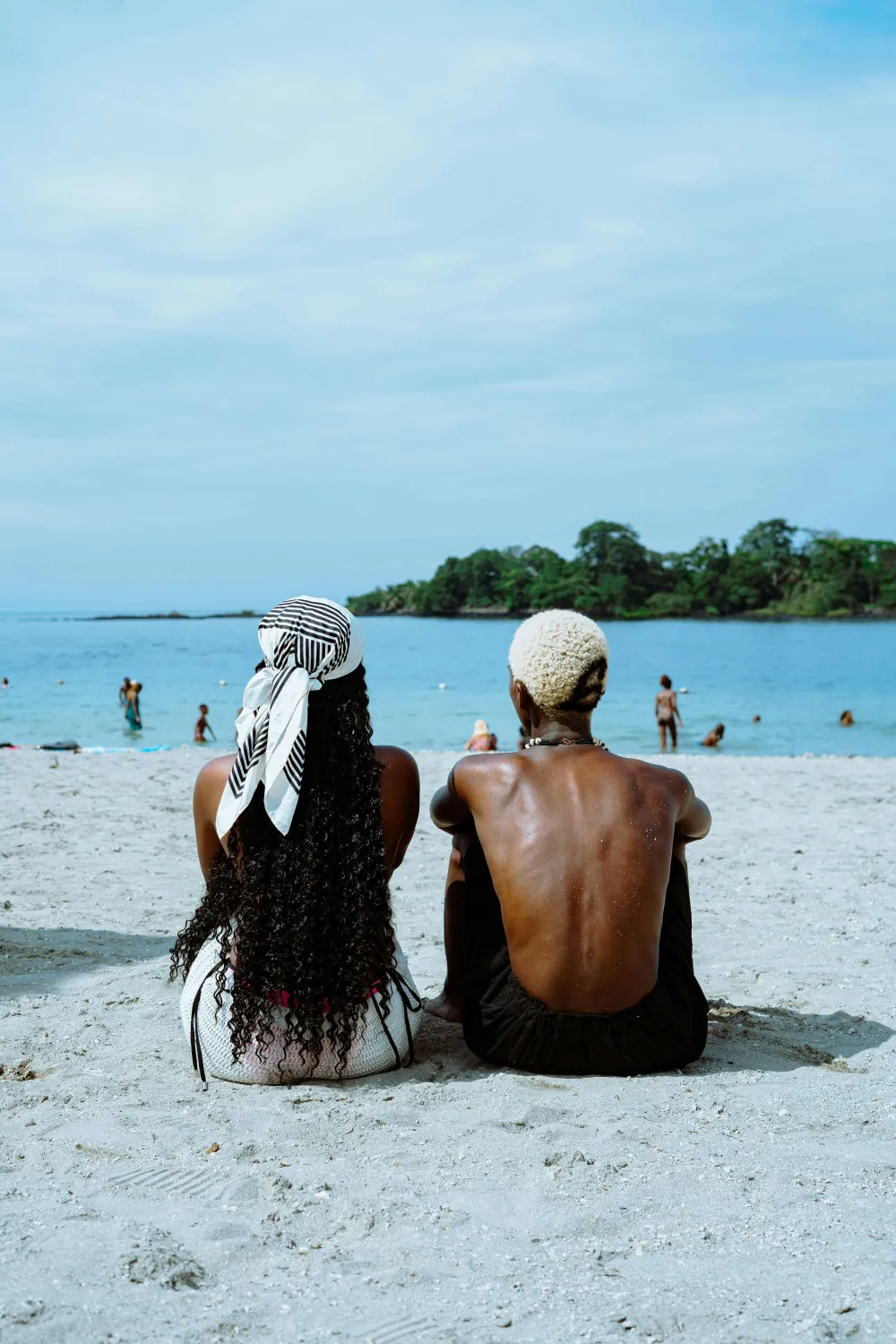 Duas pessoas sentadas lado a lado na praia